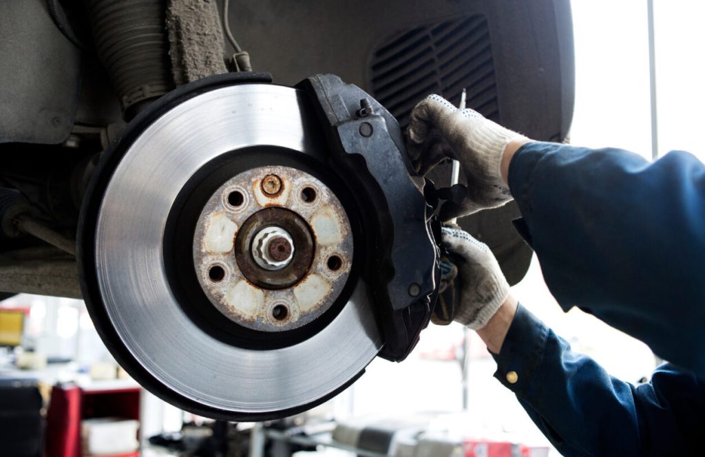 A service technician working on vehicle brakes.